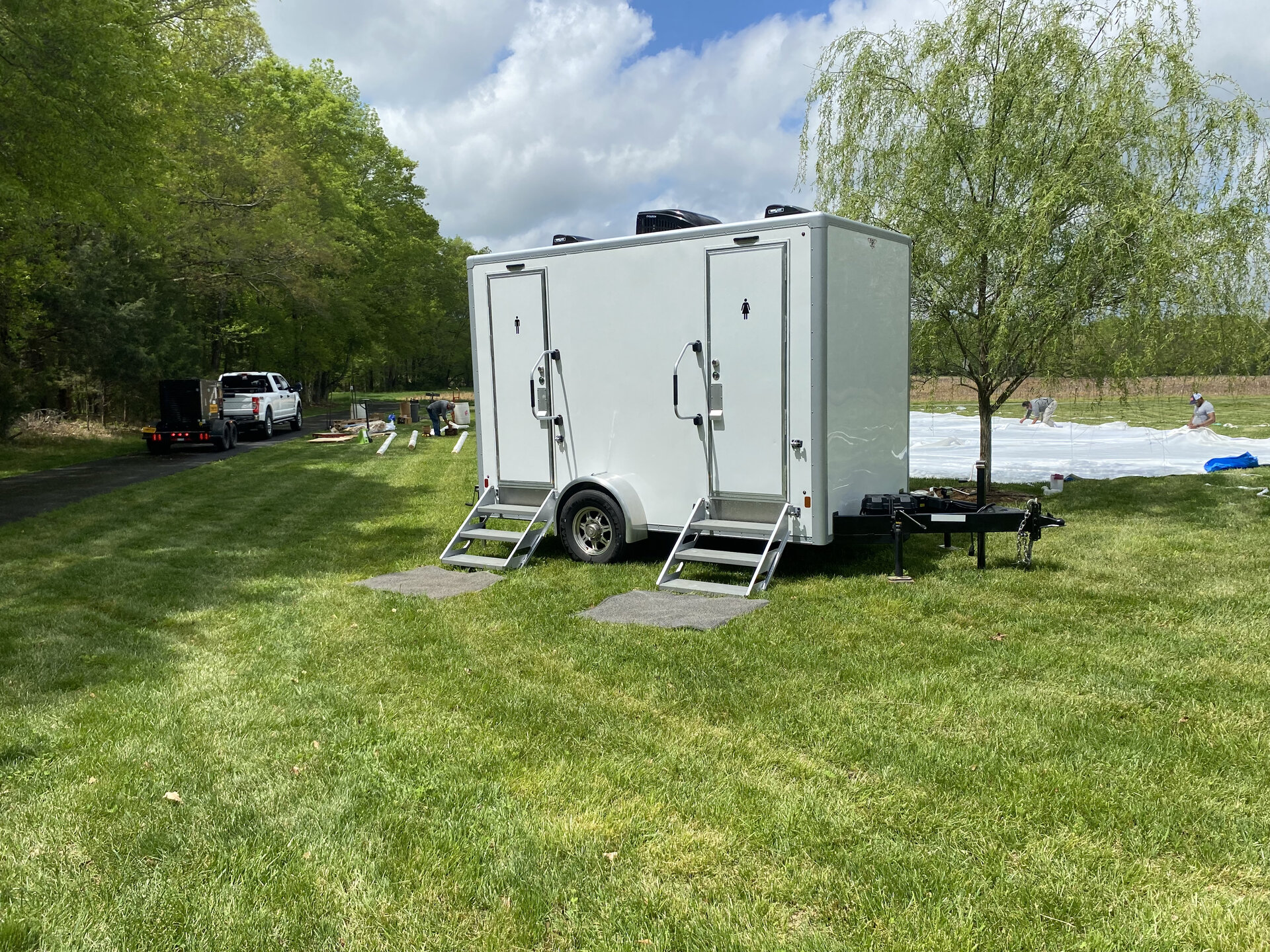 Grand Luxury 3 station restroom trailer positioned beside an outdoor reception