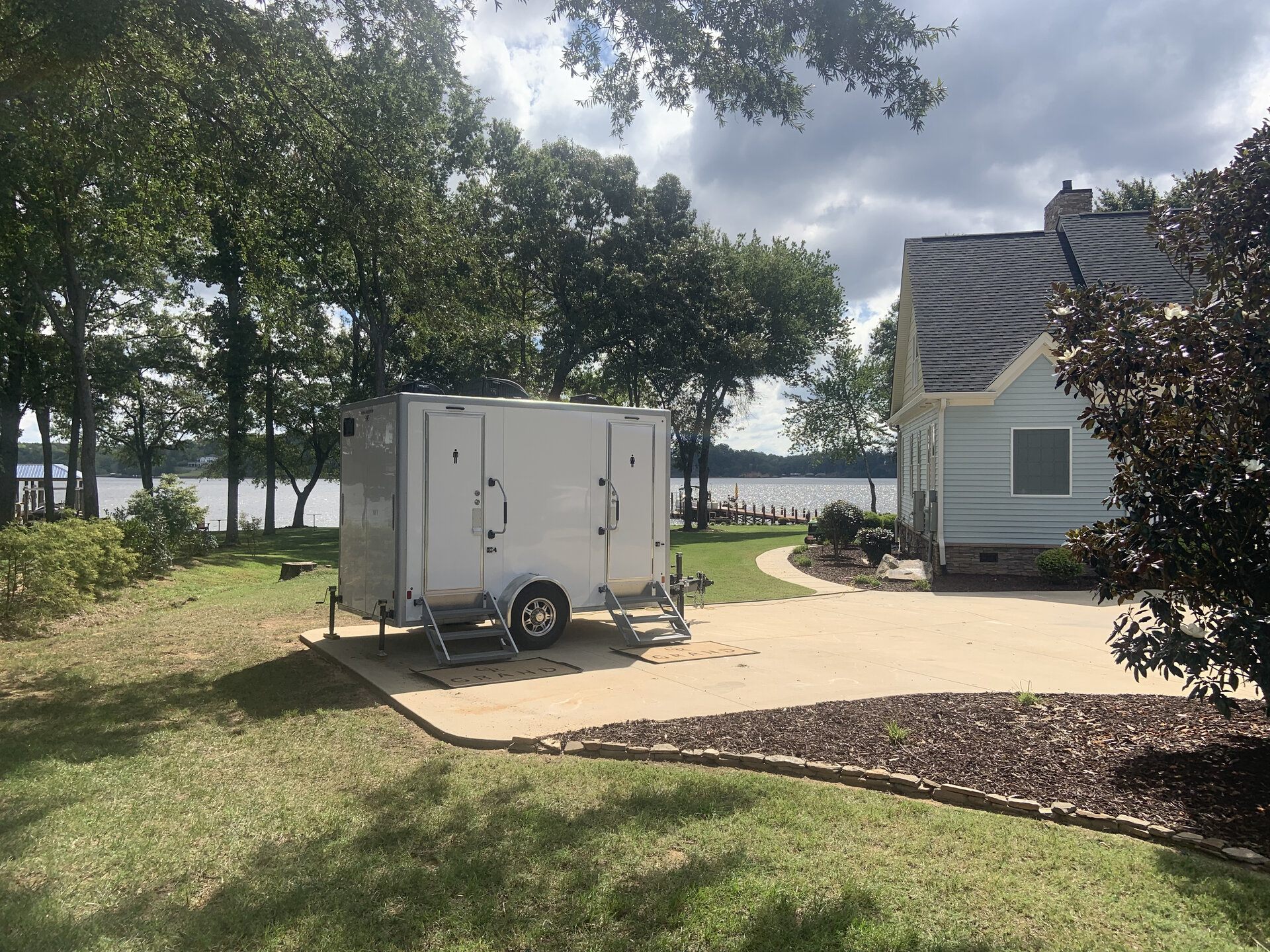 Luxury restroom trailer venue green setup staged by Grand Restrooms for Carolina weddings and corporate events