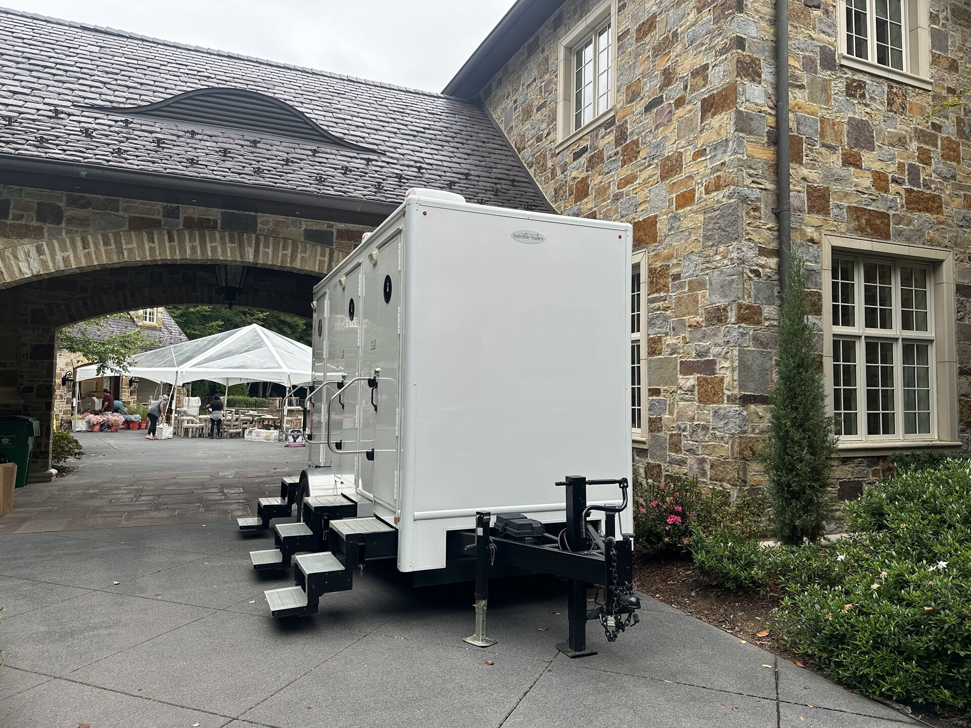 Portable restrooms lined up with twice-weekly service signage